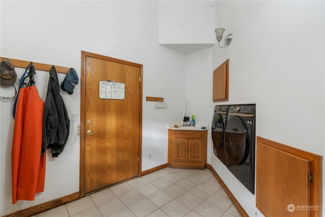 laundry area with cabinets, washer and clothes dryer, and light tile patterned flooring