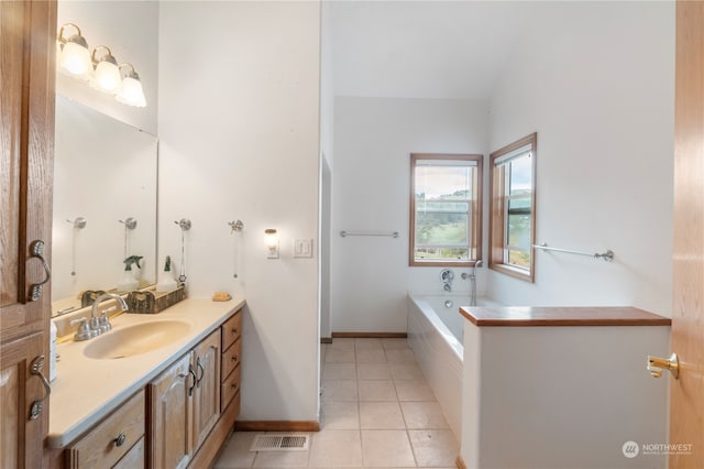 bathroom featuring tile patterned flooring, vanity, and a relaxing tiled tub