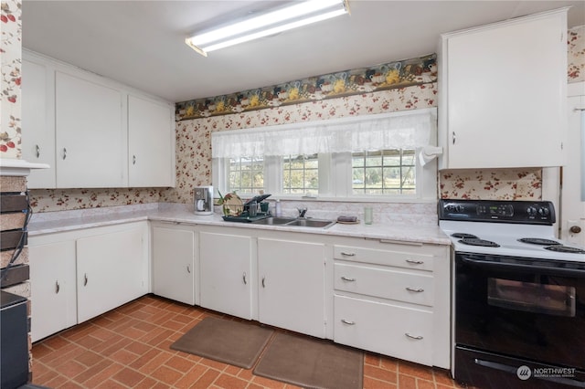 kitchen featuring white cabinets, tasteful backsplash, white range with electric cooktop, and sink