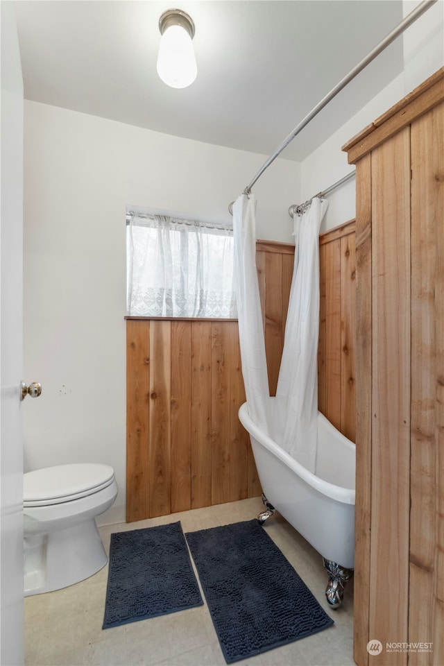 bathroom featuring toilet and shower / tub combo with curtain