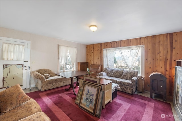 living room with dark carpet and wood walls