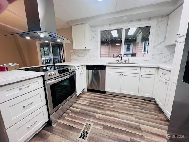 kitchen featuring sink, light wood-type flooring, island range hood, white cabinetry, and stainless steel appliances