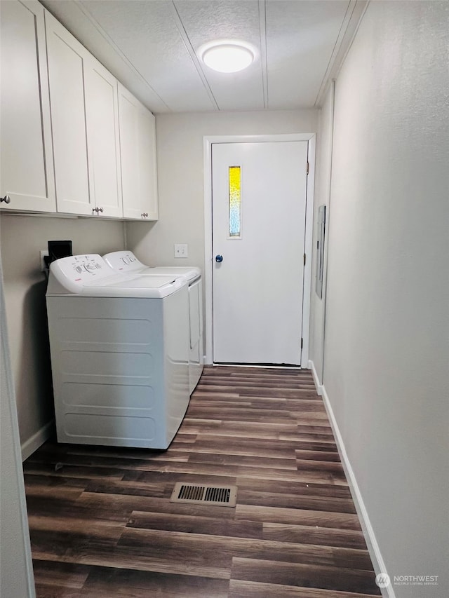 clothes washing area with cabinets, dark wood-type flooring, and independent washer and dryer