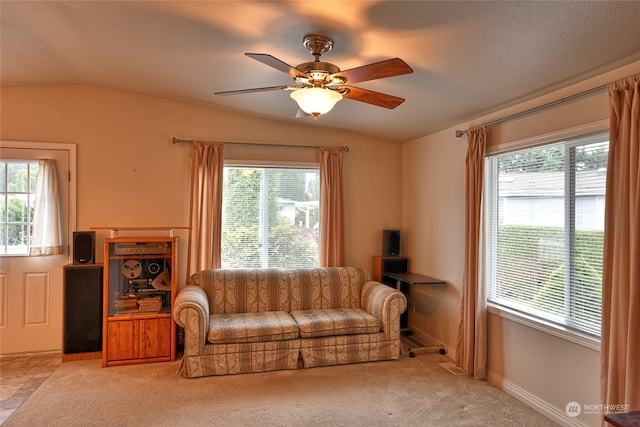 carpeted living room with ceiling fan and lofted ceiling