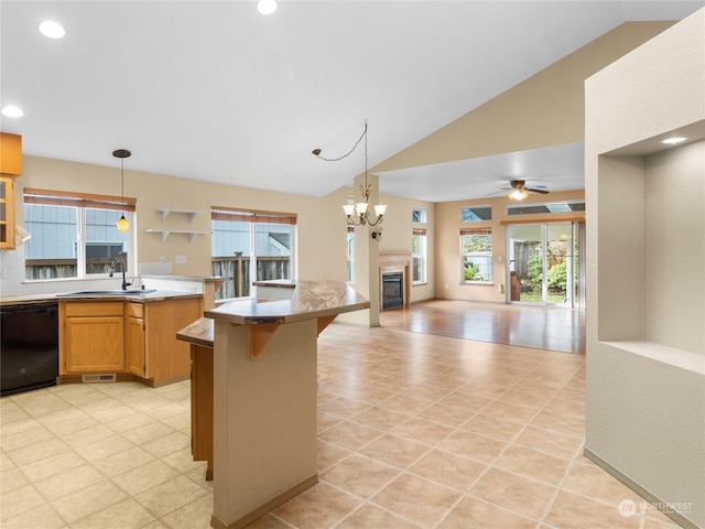 kitchen featuring dishwasher, a kitchen breakfast bar, lofted ceiling, and decorative light fixtures