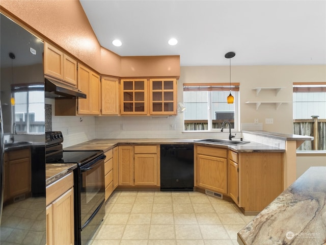 kitchen with kitchen peninsula, tasteful backsplash, sink, black appliances, and pendant lighting