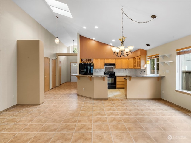 kitchen featuring a skylight, high vaulted ceiling, a notable chandelier, kitchen peninsula, and black appliances