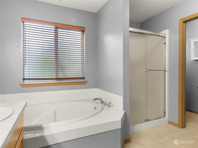 bathroom featuring vanity and shower with separate bathtub