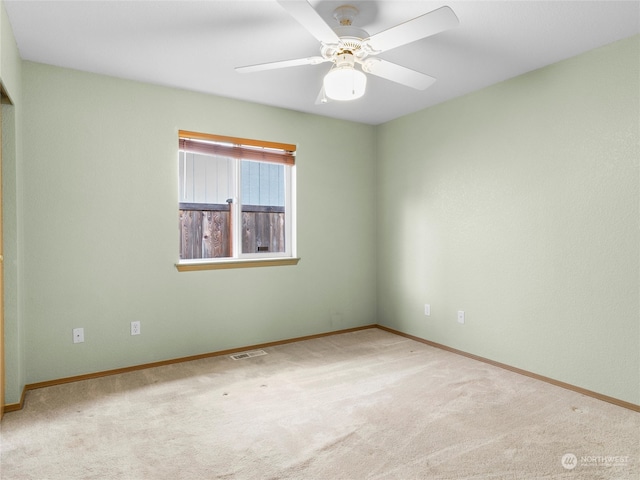 unfurnished room with light colored carpet and ceiling fan