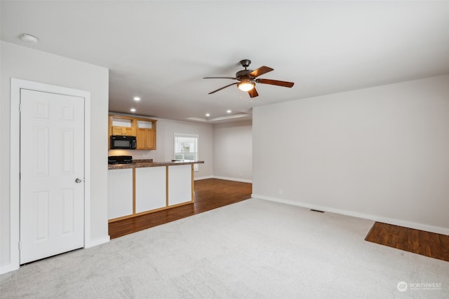 unfurnished living room with ceiling fan and light carpet