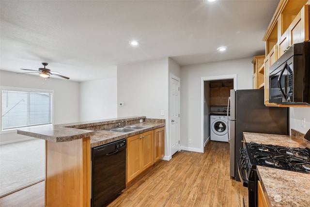 kitchen featuring light hardwood / wood-style floors, ceiling fan, sink, black appliances, and washer / clothes dryer