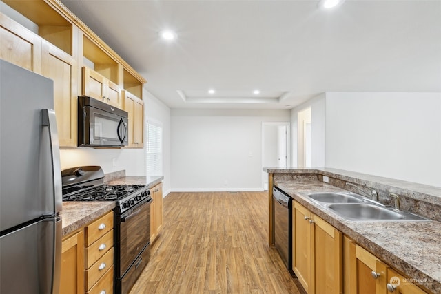 kitchen featuring sink, black appliances, and light wood-type flooring