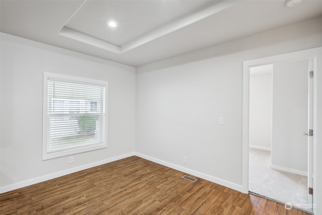 unfurnished room featuring hardwood / wood-style floors and a tray ceiling