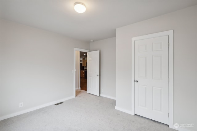 unfurnished bedroom featuring light carpet