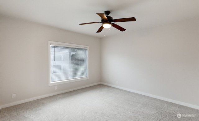 empty room featuring ceiling fan and carpet