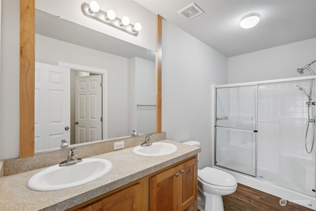 bathroom with toilet, vanity, an enclosed shower, and hardwood / wood-style flooring