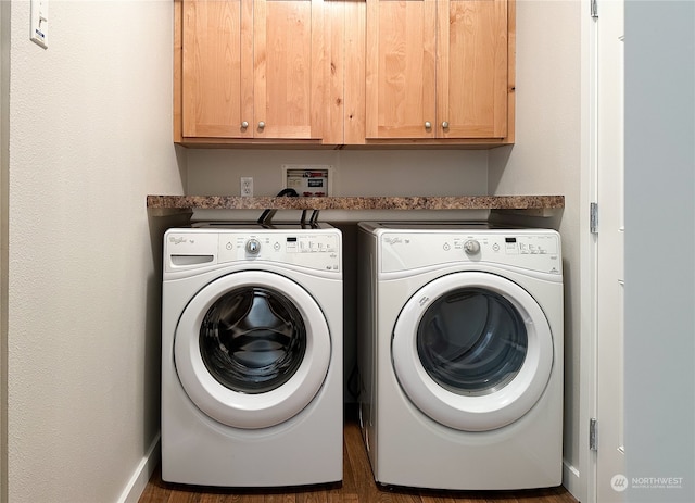 clothes washing area with cabinets and washing machine and dryer