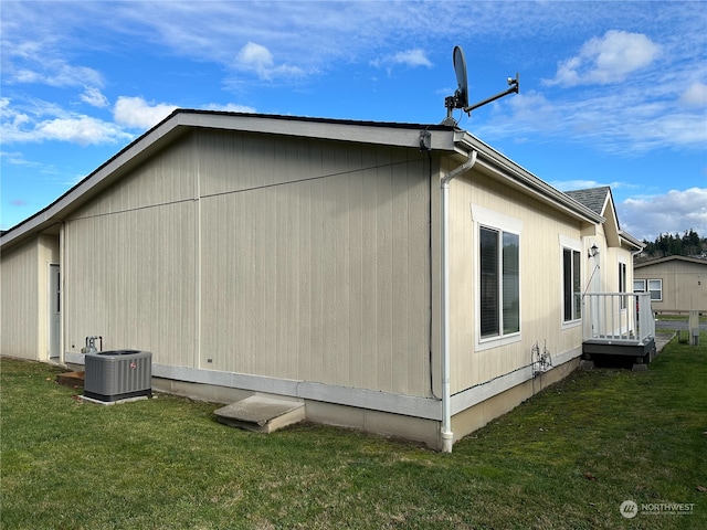 view of property exterior with central air condition unit and a yard