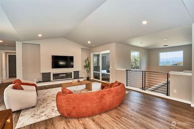 17726 142nd Ave E Unit 9, Puyallup, WA 98374 - living room featuring wood finished floors, vaulted ceiling, recessed lighting, baseboards, and a glass covered fireplace