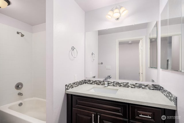 bathroom with tasteful backsplash, vanity, and tiled shower / bath