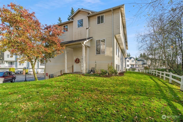 rear view of property featuring a lawn