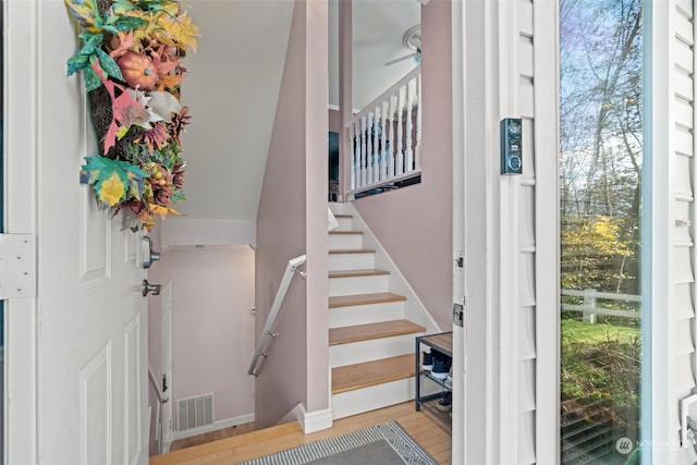 stairs with hardwood / wood-style flooring and ceiling fan