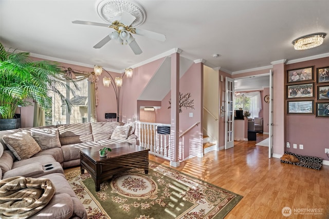 living area featuring ceiling fan, ornamental molding, light wood-style flooring, and baseboards