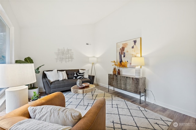 living room with hardwood / wood-style floors and lofted ceiling