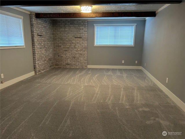 carpeted empty room with plenty of natural light and beamed ceiling