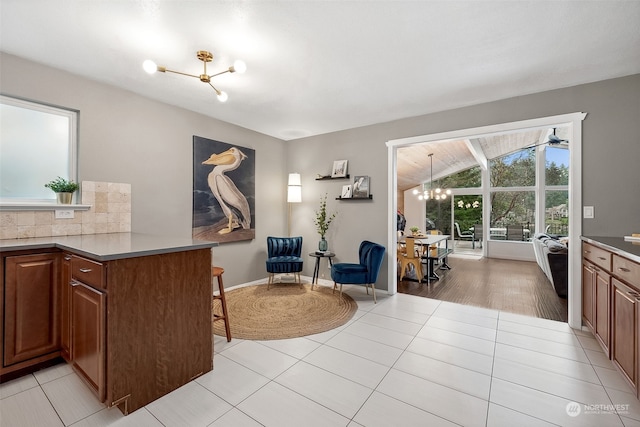 kitchen with a notable chandelier, kitchen peninsula, and light tile patterned floors