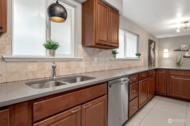 kitchen with light tile patterned floors, backsplash, stainless steel dishwasher, and sink