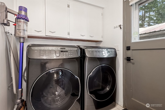 laundry area with cabinets, light tile patterned floors, and washing machine and dryer