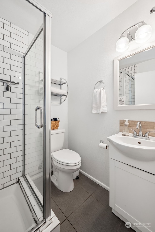 bathroom with tile patterned flooring, vanity, a shower with door, and toilet