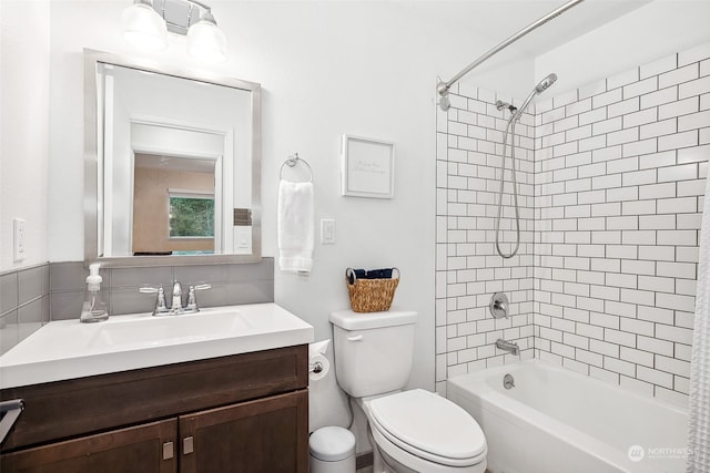 full bathroom featuring tiled shower / bath combo, toilet, and vanity