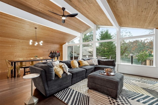 living room with vaulted ceiling with beams, a healthy amount of sunlight, wood-type flooring, and ceiling fan with notable chandelier