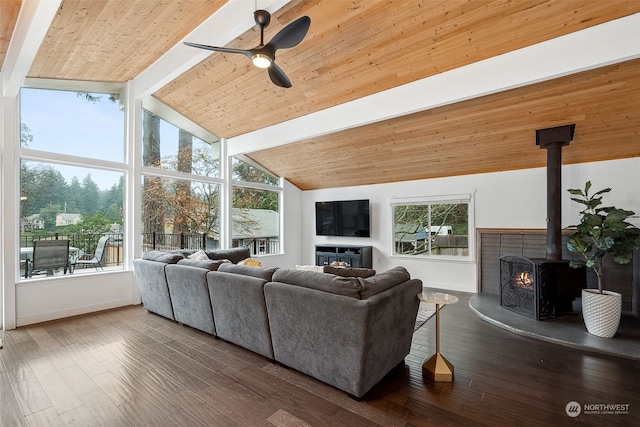 living room featuring beam ceiling, a wood stove, a wealth of natural light, and ceiling fan