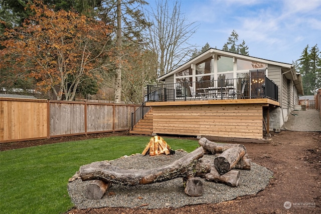 rear view of house featuring a yard and a wooden deck