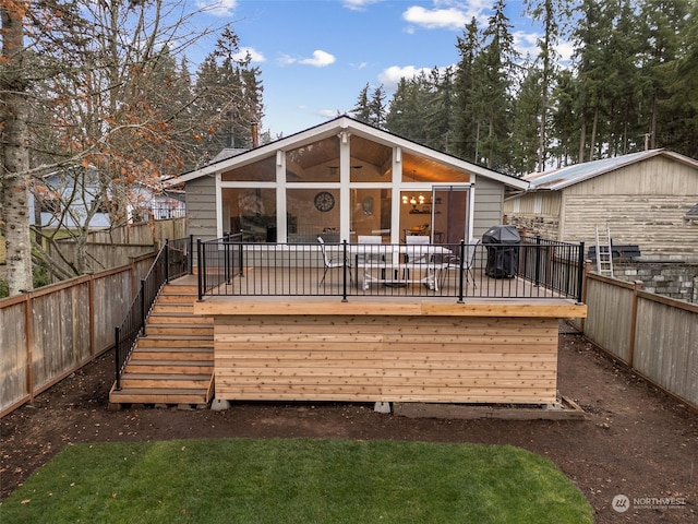 back of house with a sunroom and a wooden deck