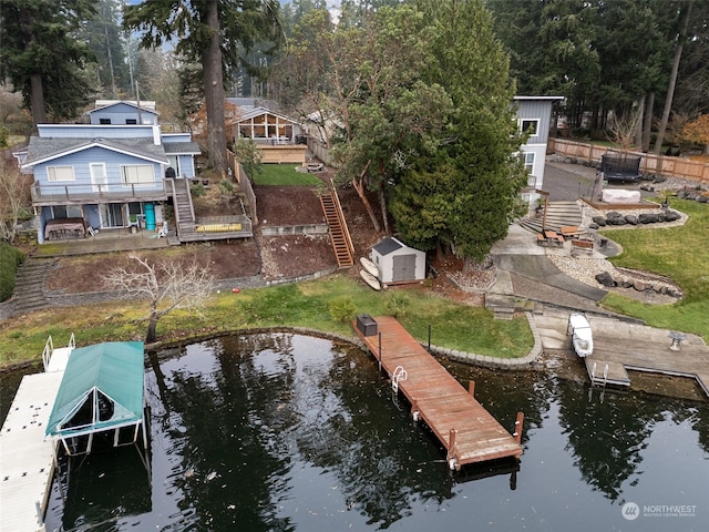 exterior space featuring a deck with water view and a yard