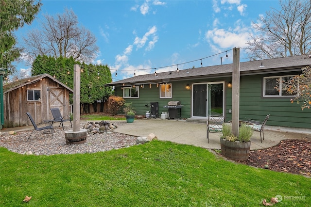 rear view of property with a yard, a patio, and a storage unit