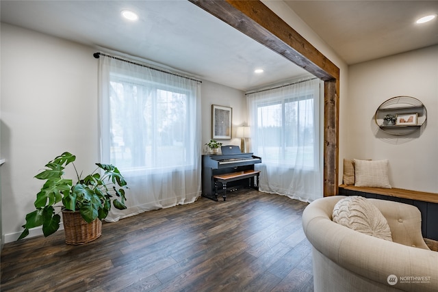 living area featuring dark hardwood / wood-style floors and beam ceiling