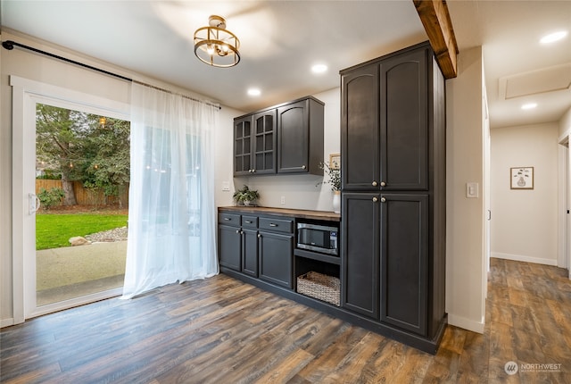 kitchen with dark hardwood / wood-style flooring, butcher block countertops, and stainless steel microwave