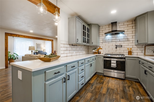 kitchen with dark hardwood / wood-style flooring, tasteful backsplash, wall chimney exhaust hood, and stainless steel range oven