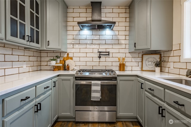 kitchen with stainless steel range, island range hood, and gray cabinetry