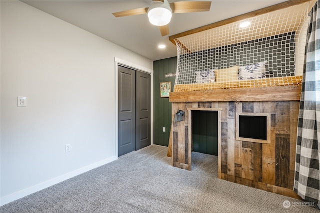 unfurnished bedroom featuring carpet, ceiling fan, and a closet