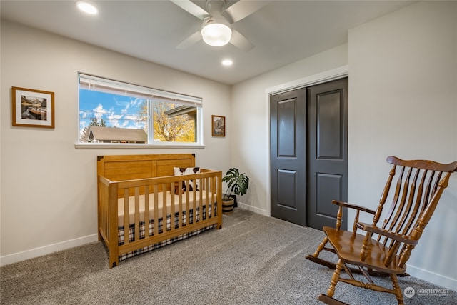 bedroom with ceiling fan, a closet, carpet, and a crib