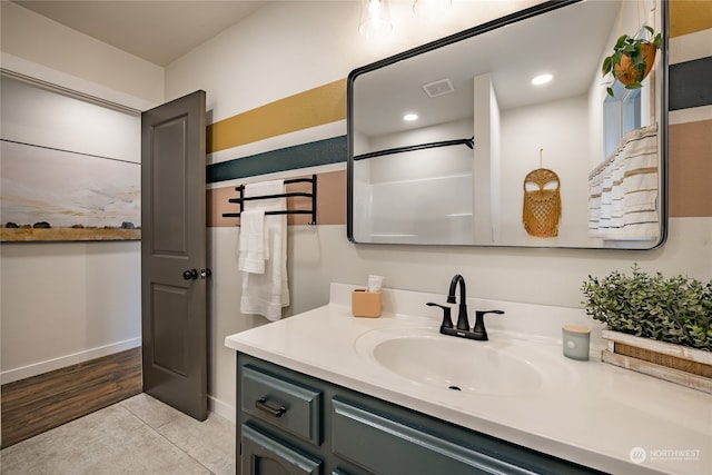 bathroom with a shower, vanity, and hardwood / wood-style flooring