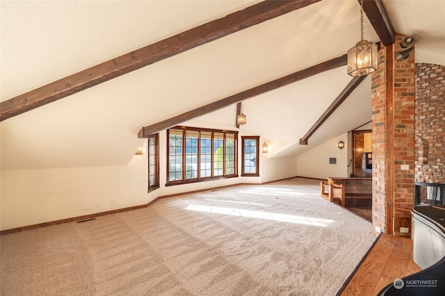 additional living space with hardwood / wood-style floors, lofted ceiling with beams, and an inviting chandelier