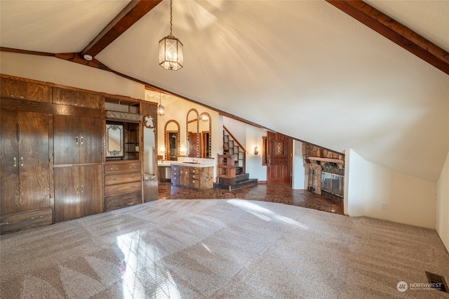 unfurnished living room featuring vaulted ceiling with beams and a stone fireplace