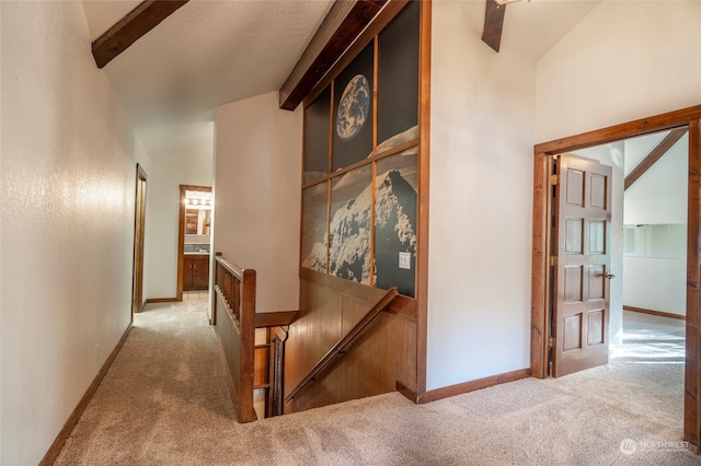 hall with beamed ceiling, light colored carpet, and high vaulted ceiling